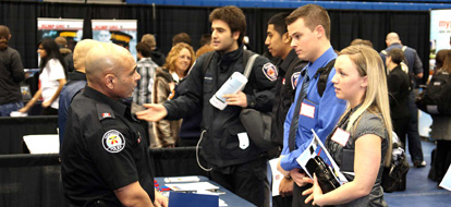 Durham College job fair students speaking to Toronto Police Service representative