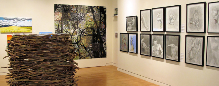 Inside a gallery with paintings on the walls and a large sculpture in the centre