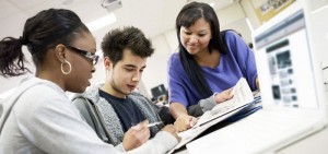 Teachers assist students in a classroom setting
