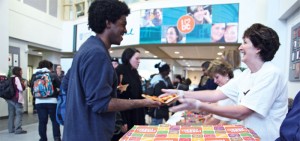 DC students receive pizza from staff members.